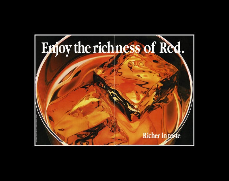 May include: A close-up of a glass filled with a reddish-brown liquid and large ice cubes. The text "Enjoy the richness of Red" is at the top, with "Richer in taste" at the bottom. The image has a vintage, retro aesthetic.