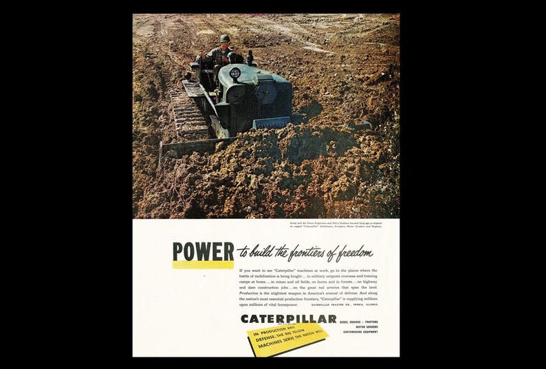 May include: Vintage advertisement featuring a Caterpillar tractor operating in a muddy field. The tractor is olive green, with a driver visible. The ad includes the text "POWER to build the frontiers of freedom" and the Caterpillar logo.