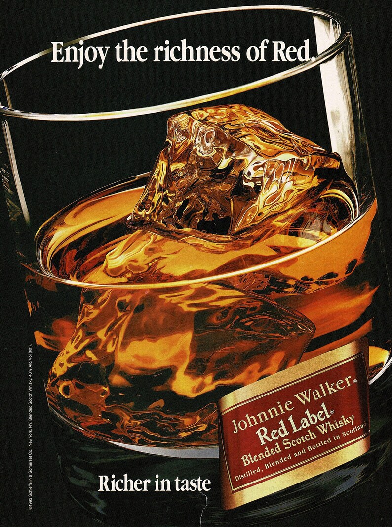 May include: A glass of amber-colored whisky with large ice cubes, reflecting light. The text "Enjoy the richness of Red" and "Richer in taste" are visible. A label for Johnnie Walker Red Label Blended Scotch Whisky is also present.
