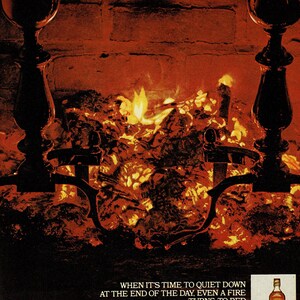May include: An advertisement featuring a fireplace with a roaring fire, flanked by black iron and brass fire tools. The text reads "When it's time to quiet down at the end of the day, even a fire turns to red." A bottle of Johnnie Walker Red is shown.