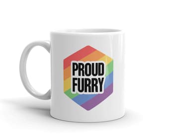 May include: White ceramic mug with a rainbow hexagonal design and the text "PROUD FURRY" in black.