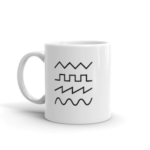 May include: White ceramic mug with black line drawings of different types of waves. The waves include a sawtooth wave, a square wave, a triangular wave, and a sine wave.