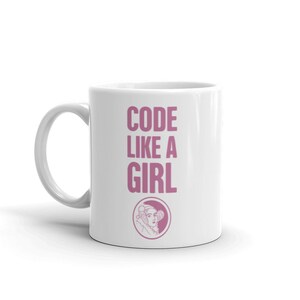 May include: White ceramic mug with a pink graphic that says "CODE LIKE A GIRL" and a pink illustration of a woman with a crown.