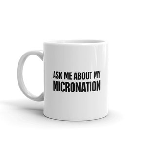 Pode incluir: Caneca de cerâmica branca com uma inscrição preta que diz "Pergunte-me sobre minha micronação".
