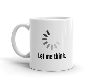 May include: White ceramic coffee mug with a black loading icon and the text "Let me think."