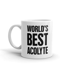 Può includere: Tazza in ceramica bianca con testo nero che recita "WORLD'S BEST ACOLYTE".