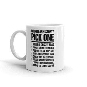 May include: White ceramic mug with black text that reads "Broken arm story? Pick one" and lists eight humorous reasons for a broken arm.