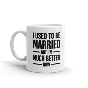 May include: White ceramic coffee mug with black text that reads "I used to be married but I'm much better now".