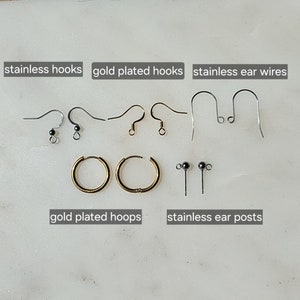May include: Assortment of earring findings including stainless steel hooks, gold plated hooks, stainless steel ear wires, gold plated hoops, and stainless steel ear posts.