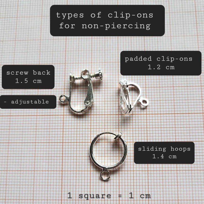 May include: Close-up of three different types of clip-on earrings for non-piercing ears. The earrings are silver-toned and measure 1.2 cm, 1.4 cm, and 1.5 cm in diameter. The text "screw back 1.5 cm adjustable" is written on a white background. The text "padded clip-ons 1.2 cm" is written on a white background. The text "sliding hoops 1.4 cm" is written on a white background. The text "1 square = 1 cm" is written on a white background.