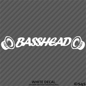 以下が含まれることがあります： グレーの背景に、スピーカーのグラフィックと「BASSHEAD」の文字が白で描かれたステッカー。下部には「WHITE DECAL (SHOWN ON GRAY BACKGROUND)」の文字。カーオーディオ愛好家向けアクセサリー。