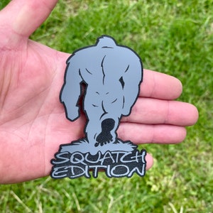 May include: A gray vinyl sticker of a Bigfoot walking away with the text "Squatch Edition" underneath.
