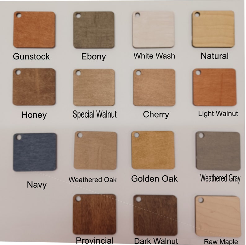 May include: A collection of wooden square color samples, each with a small hole for hanging. Colors include Gunstock, Ebony, White Wash, Natural, Honey, Special Walnut, Cherry, Light Walnut, Navy, Weathered Oak, Golden Oak, Weathered Gray, Provincial, Dark Walnut, and Raw Maple.