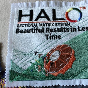 May include: Embroidered patch with the word "HALO" in black, a colorful circular design, and the text "SECTIONAL MATRIX SYSTEM Beautiful Results in Less Time." The patch features a brown and orange design on a green background.