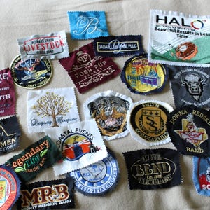 May include: A collection of embroidered patches with various designs and text. Patches include company logos, text like "HALO," "Legacy Hospice," and "Mighty Redskin Band." Colors include blue, red, gold, and black. The patches are of various shapes and sizes.