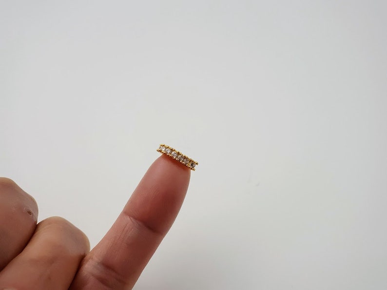 Puede incluir: Un anillo de oro con peque&ntilde;as piedras transparentes engastadas en una banda.