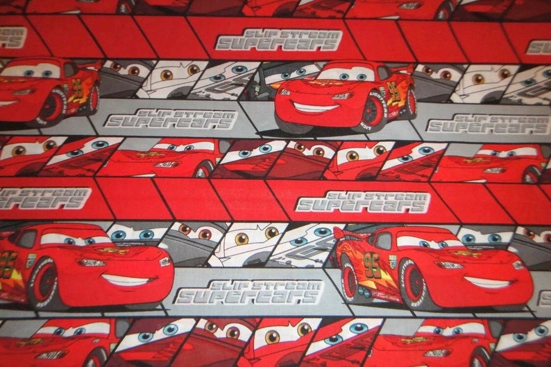 Puede incluir: Tela roja y gris con un patr&oacute;n repetido de un coche de carreras rojo con el n&uacute;mero 95 en el lateral. El texto "Slip Stream Supercars" se repite en toda la tela.