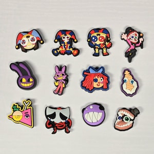 May include: A collection of colorful cartoon character shoe charms. The charms feature various designs, including jesters, rabbits, and other whimsical figures. The charms are made of rubber and are designed to be attached to shoes.