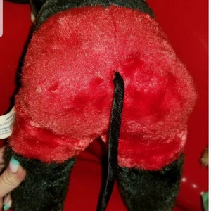 K&ouml;nnte beinhalten: Ein Pl&uuml;schtier von Mickey Mouse, das eine rote Hose mit einem schwarzen Schwanz tr&auml;gt. Das Spielzeug ist aus weichem, flauschigem Stoff und hat eine schwarze Nase und Augen.
