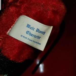 K&ouml;nnte beinhalten: Ein wei&szlig;es Etikett mit blauem Text, auf dem "Walt Disney Character &copy; Walt Disney Productions" steht.
