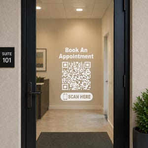 May include: Black framed glass door with white text that says "Book An Appointment" above a QR code and the words "SCAN HERE". Suite 101 sign is on the left.
