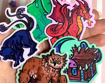 May include: A collection of fantasy-themed stickers featuring a red dragon, a black panther, a brown owl-bear hybrid, a green hill with a sword, and a treasure chest. The stickers have a white border and are on a pink and white striped background.