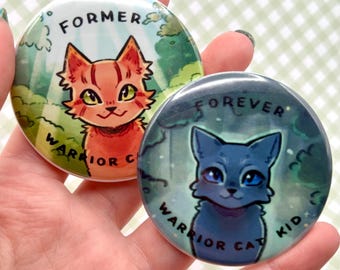 Puede incluir: Dos botones redondos con ilustraciones de gatos. Un botón tiene un gato naranja con el texto "FORMER WARRIOR CAT". El otro botón tiene un gato azul con el texto "FOREVER WARRIOR CAT KID". El fondo de cada botón es una escena de bosque.