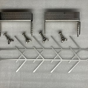May include: Two silver metal brackets with a wood-like finish, four silver screws with nuts, and six silver metal rods with a zig-zag pattern.