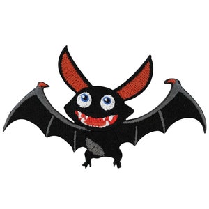 Könnte beinhalten: Eine schwarze und graue Cartoon-Fledermaus mit roten Ohren und großen blauen Augen. Die Fledermaus lächelt mit offenem Mund und zeigt ihre Zähne.