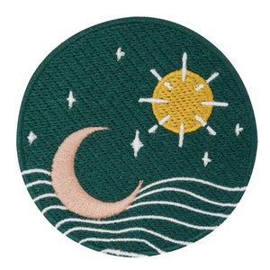 Puede incluir: Un parche bordado verde con una luna creciente rosa, un sol amarillo y estrellas blancas sobre un fondo verde. La luna y el sol están sobre un diseño de ola blanca.