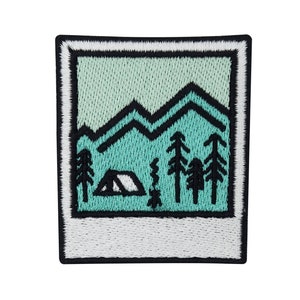 May include: An embroidered patch with a photo frame design. The image inside the frame is a green and black illustration of a mountain range, trees, and a tent.