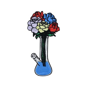 May include: A colourful bouquet of flowers in a blue glass bong.