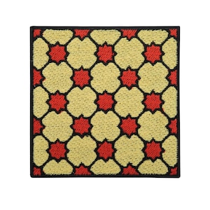 Può includere: Un cerotto ricamato quadrato con un motivo geometrico di stelle rosse e fiori gialli su sfondo nero.