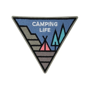 Peut inclure: Un écusson brodé en forme de triangle avec un fond bleu, des montagnes grises, une tente rose et blanche et des arbres turquoise. Le texte "CAMPING LIFE" est en blanc.