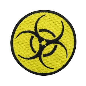 Può includere: Toppa circolare gialla con un simbolo di rischio biologico nero. Il simbolo è un design stilizzato a tre punte.