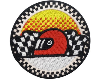 Könnte beinhalten: Ein runder gestickter Aufnäher mit einer karierten Flagge, einem roten Rennhelm und einer gelben Sonne mit roten Punkten. Der Aufnäher ist schwarz und weiß mit einem weißen Rand.