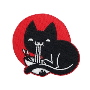 Könnte beinhalten: Eine schwarze Katze mit einem glücklichen Ausdruck isst Nudeln aus einer Schüssel. Die Katze sitzt auf einem roten Kreis als Hintergrund.