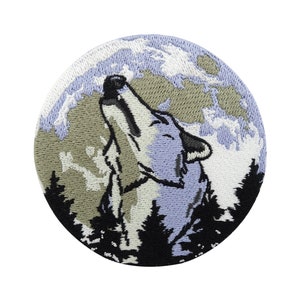 May include: Embroidered patch of a wolf howling at the moon. The wolf is a light blue colour with a white outline. The moon is a light brown colour with white clouds. The background is a dark green colour.