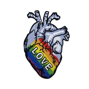 Könnte beinhalten: Ein gestickter Patch mit einem Regenbogenherz und dem Wort "LOVE" in weißen Buchstaben.