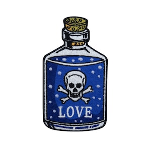 Könnte beinhalten: Eine blaue Glasflasche mit einem Korkverschluss und einem Totenkopf- und Knochenkreuz-Design. Die Flasche ist mit einer blauen Flüssigkeit gefüllt und trägt den Schriftzug "LOVE" auf der Vorderseite.