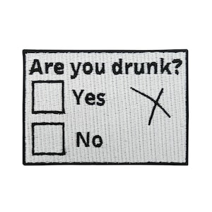 Könnte beinhalten: Weißer gestickter Patch mit schwarzem Text, der "Are you drunk?" lautet, mit zwei Kontrollkästchen darunter. Das erste Kontrollkästchen ist mit "Yes" beschriftet und hat ein "X" durchgestrichen. Das zweite Kontrollkästchen ist mit "No" beschriftet.