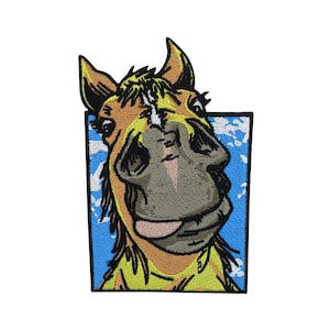 Könnte beinhalten: Ein gestickter Aufnäher mit einem Cartoon-Pferd mit gelber Mähne und braunem Körper, das zur Seite schaut und die Zunge herausstreckt. Das Pferd ist vor einem blauen Hintergrund mit weißen Wolken platziert.