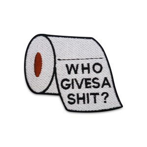 Op de afbeelding: Geborduurde patch met een rol toiletpapier met een bruin midden. De patch heeft de tekst "WHO GIVES A SHIT?" in zwart, met een zwarte rand. De patch is wit.