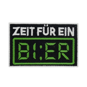 Può includere: Toppa ricamata nera e verde con testo bianco che recita "Zeit fur ein Bier" con un display digitale verde che indica "8:18".