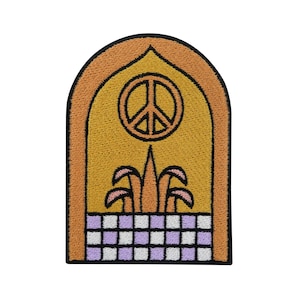 Può includere: Una toppa ricamata gialla e arancione con un segno di pace al centro, un design di pianta stilizzato sotto e un motivo a scacchi in basso.