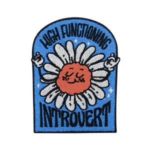 Könnte beinhalten: Blauer gestickter Aufnäher mit einer weißen Margerite mit einem roten lächelnden Gesicht. Der Text "High Functioning Introvert" ist in Schwarz gestickt.