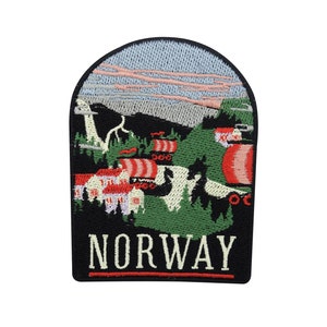 Könnte beinhalten: Gestickter Aufnäher mit einer malerischen Ansicht einer norwegischen Landschaft. Der Aufnäher zeigt eine Bergkette, einen Fluss und ein Dorf mit traditionellen Häusern. Der Text "NORWAY" ist in Weiß auf schwarzem Hintergrund gestickt.