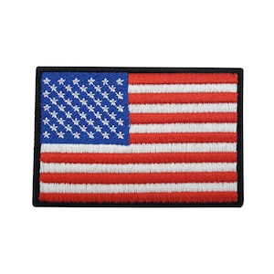 Op de afbeelding: Een geborduurde Amerikaanse vlagpatch met een zwarte rand. De vlag is rood, wit en blauw met 13 strepen en 50 sterren.