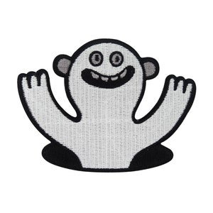 Könnte beinhalten: Weißer gestickter Aufnäher mit einem lächelnden Monster mit zwei großen Augen und ausgestreckten Armen. Das Monster kommt aus einem schwarzen Loch.