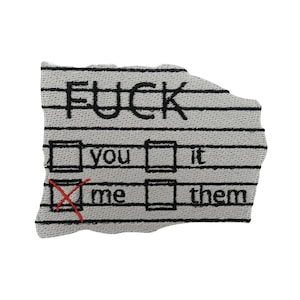 May include: A white fabric patch with black embroidery that reads "F*CK" and a multiple choice question with the options "you", "it", "me", and "them". The option "me" is checked with a red X.